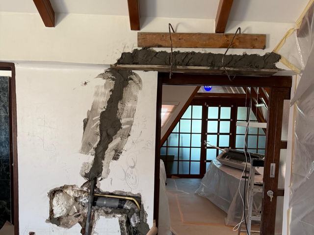 Lintel re-cast over a doorway and the pipe chase closed with mortar